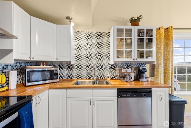 1291 Channel Ave SW, Ocean Shores, WA 98569 - kitchen with appliances with stainless steel finishes, wooden counters, a sink, and tasteful backsplash