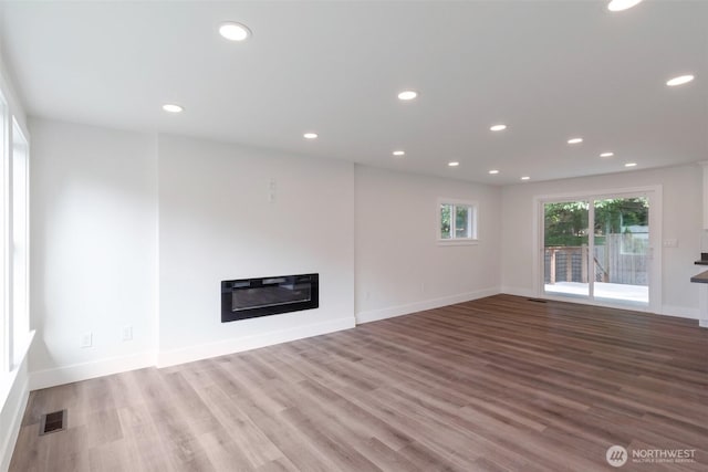 2015 172nd Pl SE, Bothell, WA 98012 - unfurnished living room featuring a glass covered fireplace, wood finished floors, recessed lighting, and baseboards