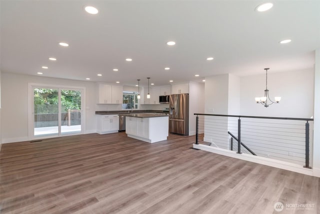 2015 172nd Pl SE, Bothell, WA 98012 - kitchen with stainless steel appliances, dark countertops, white cabinetry, a kitchen island, and baseboards