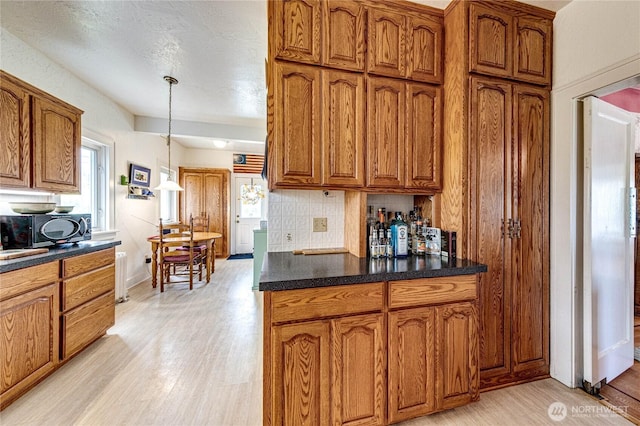 1324 E 2nd St, Port Angeles, WA 98362 - kitchen with brown cabinetry, light wood finished floors, and decorative light fixtures