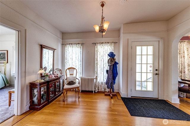 1324 E 2nd St, Port Angeles, WA 98362 - foyer featuring radiator, healthy amount of natural light, light wood-style flooring, and arched walkways