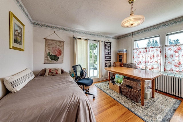 1324 E 2nd St, Port Angeles, WA 98362 - bedroom featuring radiator, wood finished floors, and a textured ceiling