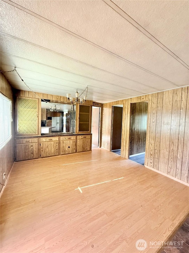 1485B Old Hwy 97, Malott, WA 98840 - unfurnished living room with a textured ceiling, wooden walls, and wood finished floors