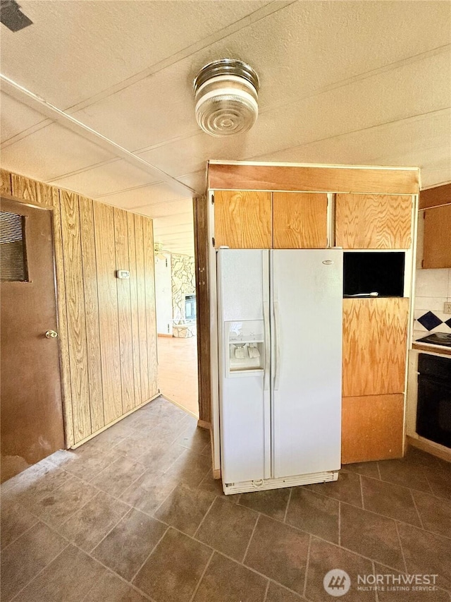 1485B Old Hwy 97, Malott, WA 98840 - kitchen with white refrigerator with ice dispenser, wall oven, wooden walls, a textured ceiling, and black electric cooktop