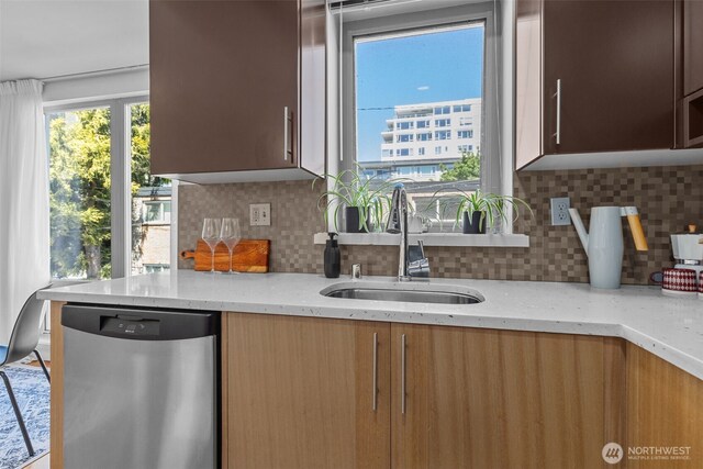 500 5th Ave W Unit 501, Seattle, WA 98119 - kitchen featuring dishwasher, a sink, light stone counters, and backsplash