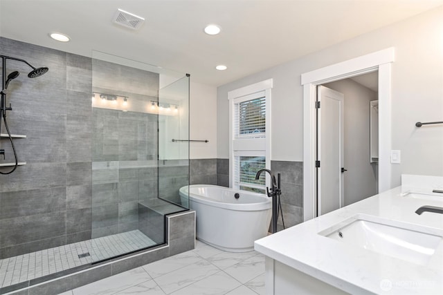 7547 S 130th Pl, Seattle, WA 98178 - bathroom featuring double vanity, tiled shower, a freestanding tub, marble finish flooring, and recessed lighting