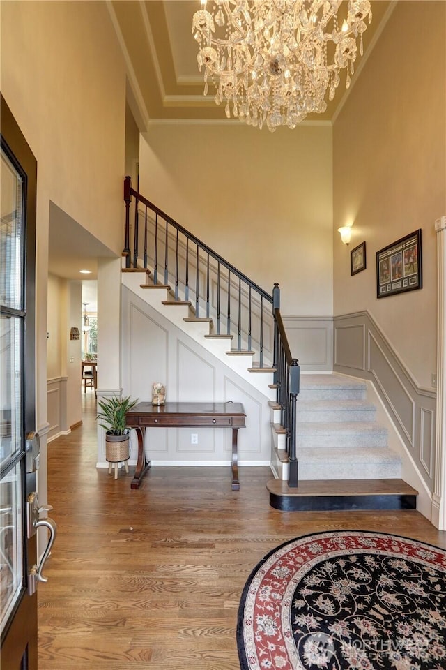 5920 228th Ave NE, Redmond, WA 98053 - stairs with a decorative wall, a chandelier, a towering ceiling, wood finished floors, and crown molding