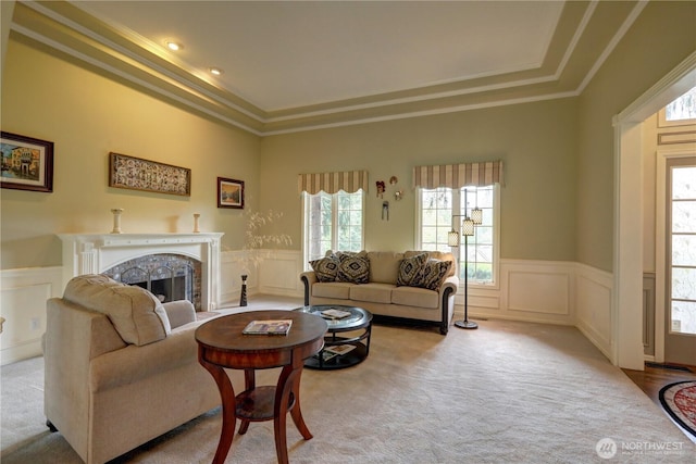 5920 228th Ave NE, Redmond, WA 98053 - carpeted living area featuring a decorative wall, a tray ceiling, crown molding, wainscoting, and a fireplace