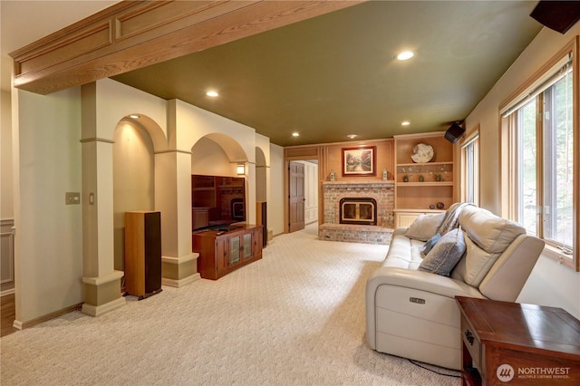 5920 228th Ave NE, Redmond, WA 98053 - living area with arched walkways, a brick fireplace, recessed lighting, light carpet, and baseboards
