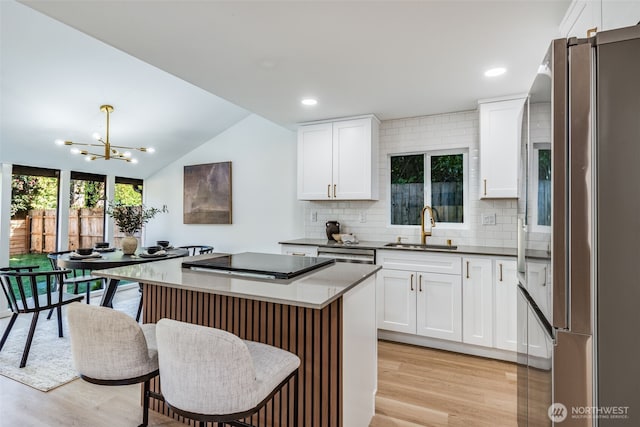 3718 W Arsenal Way, Bremerton, WA 98312 - kitchen with appliances with stainless steel finishes, a sink, a kitchen island, light wood-style flooring, and backsplash