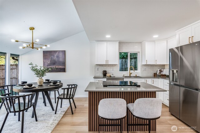 3718 W Arsenal Way, Bremerton, WA 98312 - kitchen with stainless steel refrigerator with ice dispenser, a sink, decorative backsplash, light wood-style flooring, and a center island