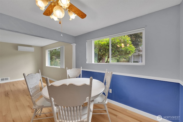 348 7th Pl SE Unit 1, Puyallup, WA 98372 - dining space featuring an AC wall unit, a ceiling fan, and wood finished floors