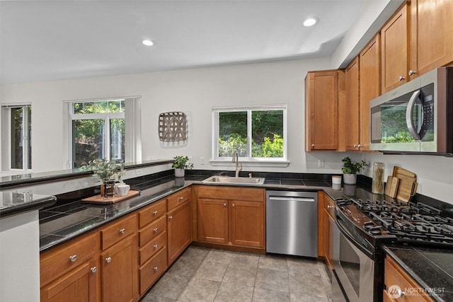 5529 Lakemont Blvd SE Unit 901, Bellevue, WA 98006 - kitchen featuring stainless steel appliances, a sink, brown cabinets, recessed lighting, and dark stone counters