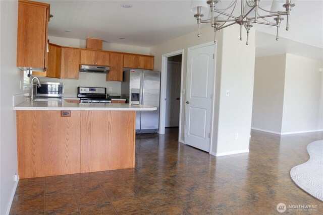 6 Laguna Pl W, Omak, WA 98841 - kitchen with appliances with stainless steel finishes, under cabinet range hood, light countertops, and brown cabinets