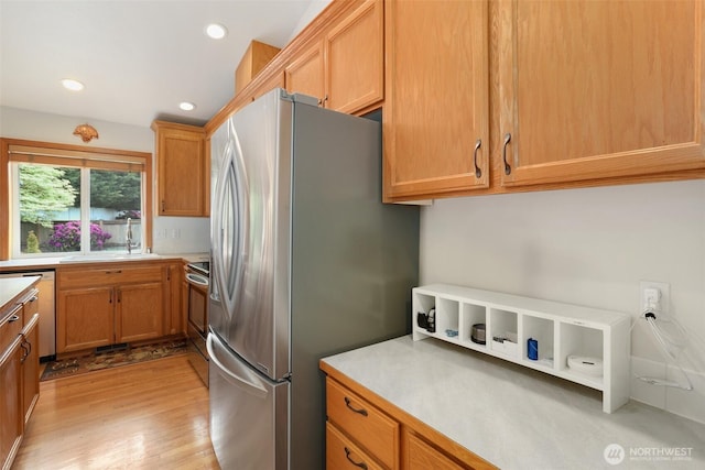 15427 148th Avenue Ct E, Orting, WA 98360 - kitchen with appliances with stainless steel finishes, light wood-type flooring, recessed lighting, light countertops, and a sink