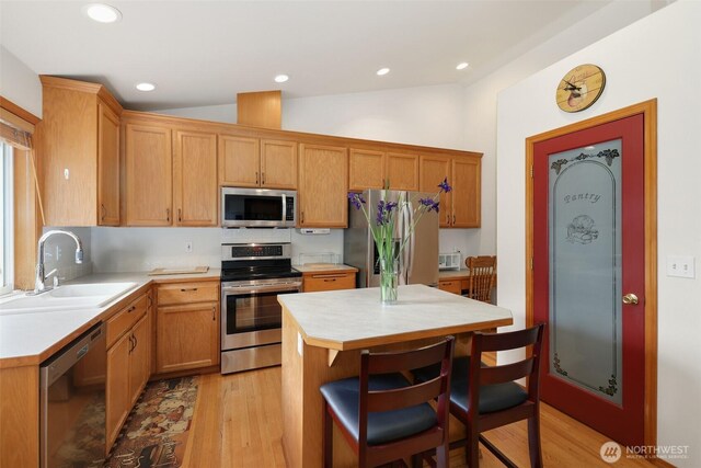 15427 148th Avenue Ct E, Orting, WA 98360 - kitchen with appliances with stainless steel finishes, a sink, light countertops, light wood finished floors, and lofted ceiling