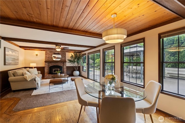 21102 31st Ave SE, Bothell, WA 98021 - dining room with healthy amount of natural light, wood finished floors, a brick fireplace, wooden ceiling with exposed beams, and a ceiling fan