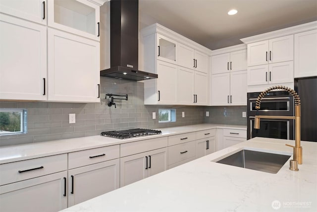 13037 75th Pl S, Seattle, WA 98178 - kitchen with wall chimney range hood, white cabinetry, stainless steel gas cooktop, a sink, and recessed lighting