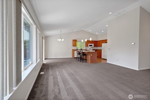 1210 24th St SE, Auburn, WA 98002 - living room featuring carpet, a chandelier, baseboards, healthy amount of natural light, and high vaulted ceiling