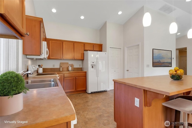 1210 24th St SE, Auburn, WA 98002 - kitchen featuring white appliances, a breakfast bar area, light countertops, and a towering ceiling