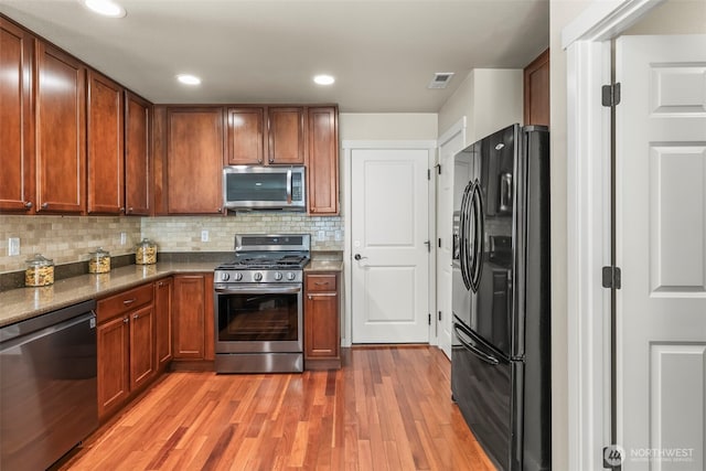 4492 Fantail Pl SW, Port Orchard, WA 98367 - kitchen featuring stainless steel appliances, light wood finished floors, decorative backsplash, brown cabinetry, and recessed lighting