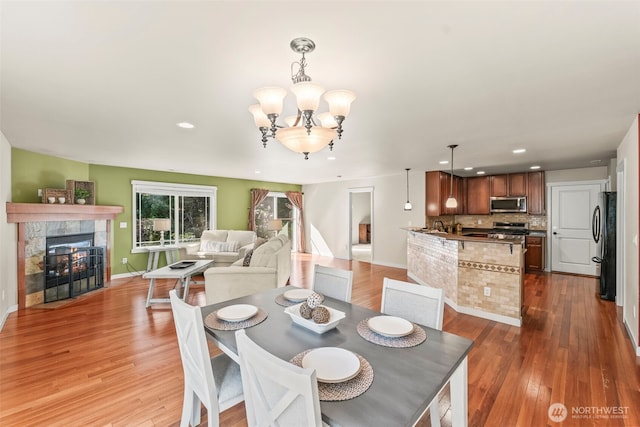 4492 Fantail Pl SW, Port Orchard, WA 98367 - dining room with recessed lighting, wood finished floors, a chandelier, a tiled fireplace, and baseboards
