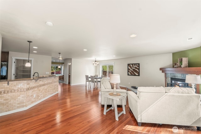 4492 Fantail Pl SW, Port Orchard, WA 98367 - living room featuring a glass covered fireplace, wood finished floors, recessed lighting, baseboards, and a chandelier