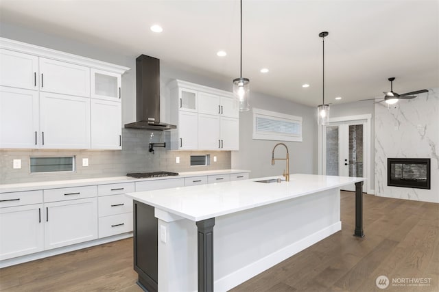 7570 S 129th Pl, Seattle, WA 98178 - kitchen featuring wall chimney exhaust hood, a sink, gas stovetop, dark wood-style floors, and an island with sink