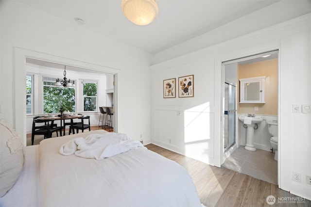 2416 Broadway, Bellingham, WA 98225 - bedroom with a chandelier, wood finished floors, and ensuite bath