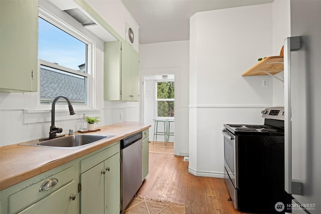 2416 Broadway, Bellingham, WA 98225 - kitchen featuring appliances with stainless steel finishes, green cabinetry, a sink, light wood-style flooring, and light countertops