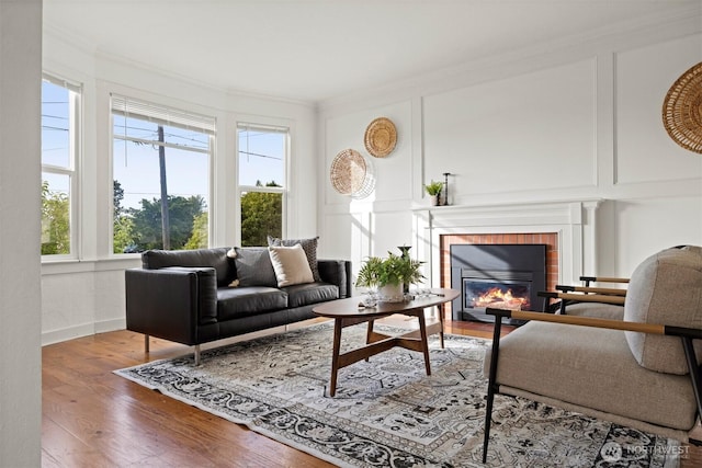 2416 Broadway, Bellingham, WA 98225 - living room featuring plenty of natural light, crown molding, wood finished floors, a fireplace, and a decorative wall