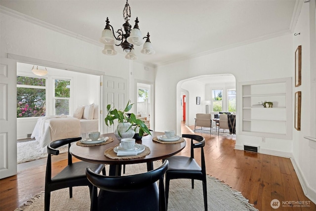 2416 Broadway, Bellingham, WA 98225 - dining room featuring ornamental molding, a chandelier, arched walkways, plenty of natural light, and built in shelves