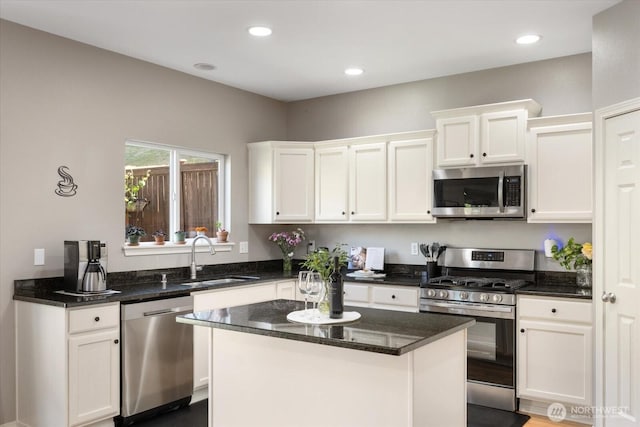 25356 SE 279th Pl, Maple Valley, WA 98038 - kitchen featuring appliances with stainless steel finishes, a sink, white cabinetry, a kitchen island, and dark stone counters