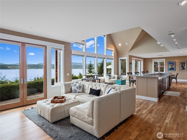 4590 E State Route 106, Union, WA 98592 - living room with light wood-style flooring, recessed lighting, a water view, french doors, and lofted ceiling