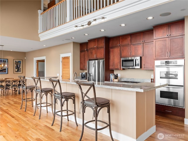 4590 E State Route 106, Union, WA 98592 - kitchen with stainless steel appliances, light wood-type flooring, a breakfast bar, a large island with sink, and recessed lighting