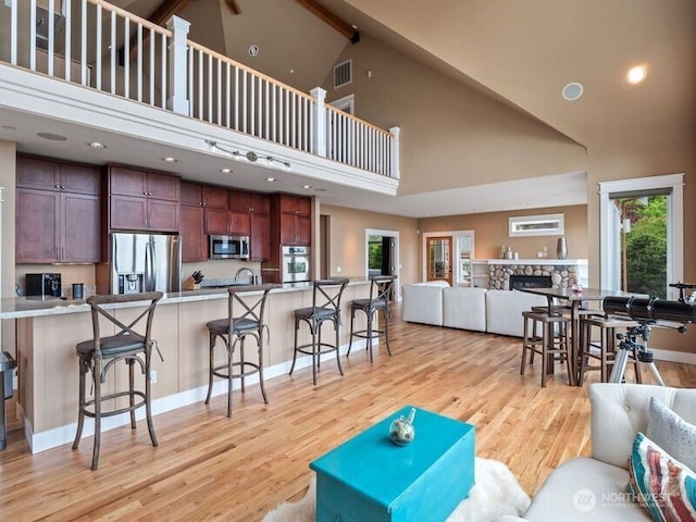4590 E State Route 106, Union, WA 98592 - living room featuring a high ceiling, light wood finished floors, plenty of natural light, a stone fireplace, and recessed lighting