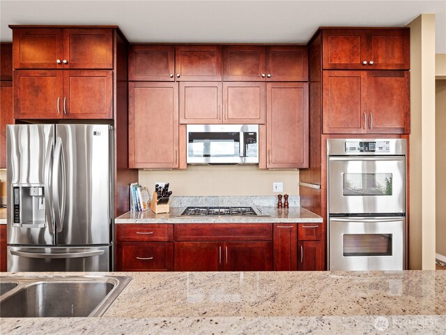 4590 E State Route 106, Union, WA 98592 - kitchen featuring stainless steel appliances, light stone countertops, and dark brown cabinets