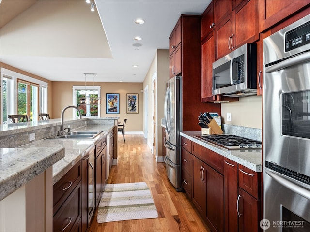 4590 E State Route 106, Union, WA 98592 - kitchen featuring stainless steel appliances, a sink, light wood-style flooring, light stone counters, and recessed lighting