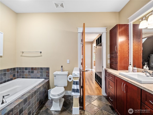 4590 E State Route 106, Union, WA 98592 - bathroom featuring a garden tub, stone tile flooring, vanity, toilet, and baseboards