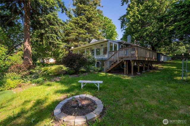2553 Mackenzie Rd, Bellingham, WA 98226 - back of house featuring stairway, an outdoor fire pit, a deck, a lawn, and a sunroom