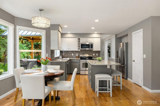 20160 Bue Rund Loop NE, Poulsbo, WA 98370 - kitchen with stainless steel appliances, gray cabinetry, tasteful backsplash, a sink, and baseboards
