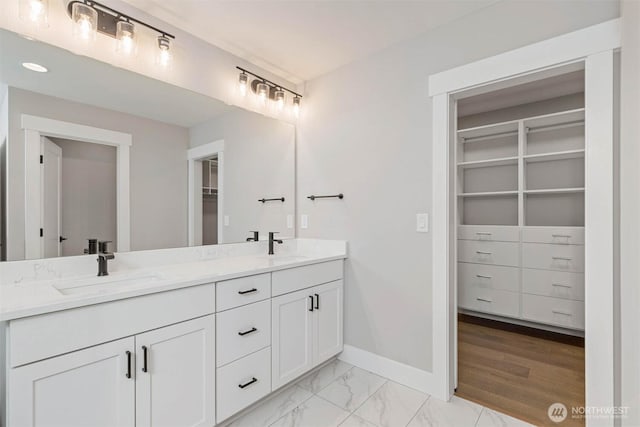7545 S 129th Pl, Seattle, WA 98178 - bathroom featuring double vanity, a spacious closet, baseboards, and marble finish flooring