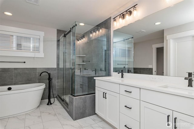7545 S 129th Pl, Seattle, WA 98178 - bathroom with a soaking tub, double vanity, marble look tiles, a shower stall, and recessed lighting