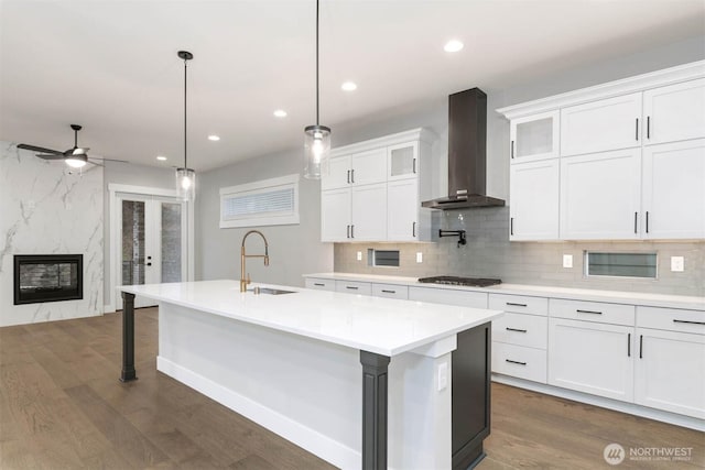 7545 S 129th Pl, Seattle, WA 98178 - kitchen with a sink, wall chimney range hood, gas cooktop, dark wood-style flooring, and a center island with sink