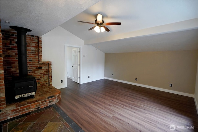 463 Humble Hill Rd, Sequim, WA 98382 - unfurnished living room featuring a wood stove, lofted ceiling, a ceiling fan, baseboards, and dark wood-type flooring