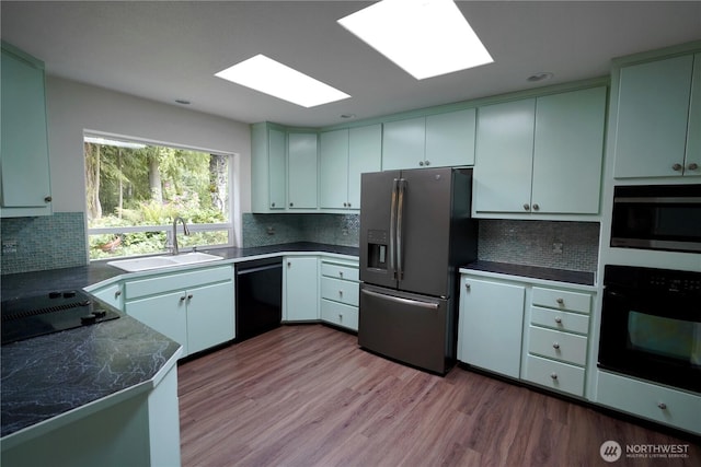 463 Humble Hill Rd, Sequim, WA 98382 - kitchen featuring black appliances, a sink, a skylight, and backsplash