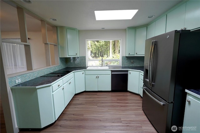 463 Humble Hill Rd, Sequim, WA 98382 - kitchen featuring dishwashing machine, stainless steel fridge with ice dispenser, a sink, black electric cooktop, and a skylight