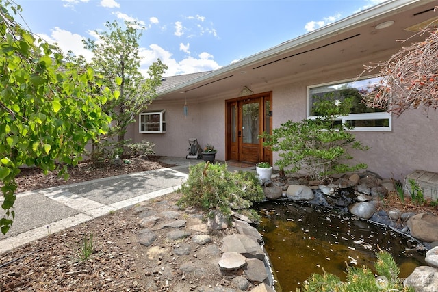 190 Twin Peaks Rd, Selah, WA 98942 - doorway to property featuring stucco siding and a small pond