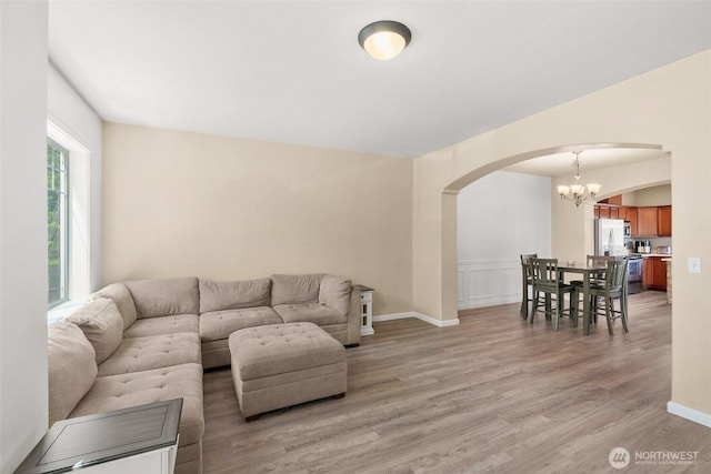 3007 Belmonte Ln, Everett, WA 98201 - living area with arched walkways, a chandelier, light wood finished floors, and baseboards