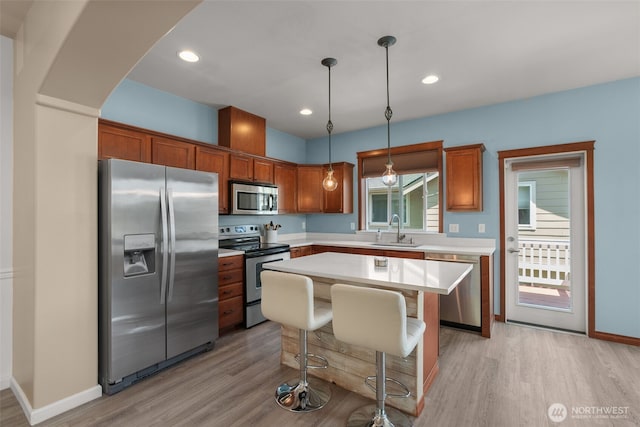 3007 Belmonte Ln, Everett, WA 98201 - kitchen with appliances with stainless steel finishes, a sink, light wood-type flooring, light countertops, and a center island